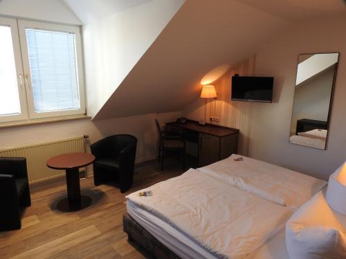 ケーテンにあるHotel Anhaltのベッドとデスクが備わるホテルルームです。