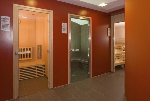 a bathroom with a walk in shower and a glass door at IG City Apartments OrchideenPark in Vienna