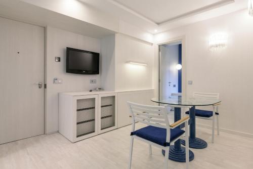 a dining room with a glass table and a tv at Santemar in Santander