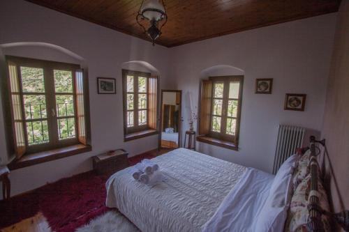 a bedroom with a white bed and windows at Casa Calda in Sirako