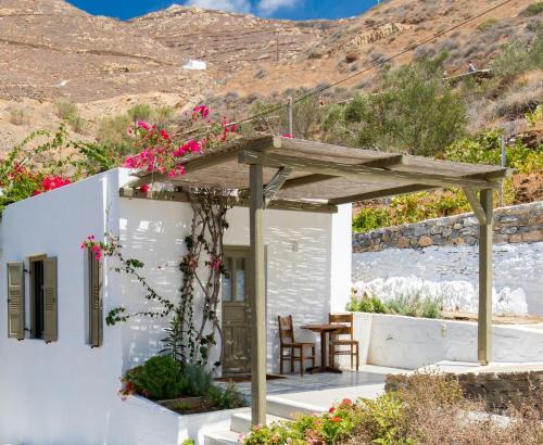 a small white house with a wooden pergola at Petradi Studios & Villa in Aegiali