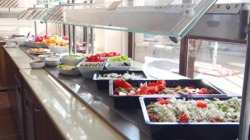 un buffet avec de nombreux plats disposés sur un comptoir dans l'établissement Moreto Seaside Aparthotel, à Obzor