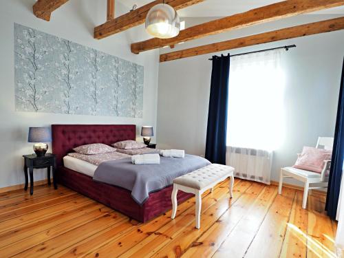 a bedroom with a large bed and a wooden floor at Berni's home Apartament z tarasem in Sopot