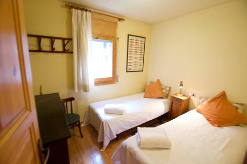 Zimmer mit 2 Betten und einem Fenster in der Unterkunft Casa Torreons in Puigcerdà