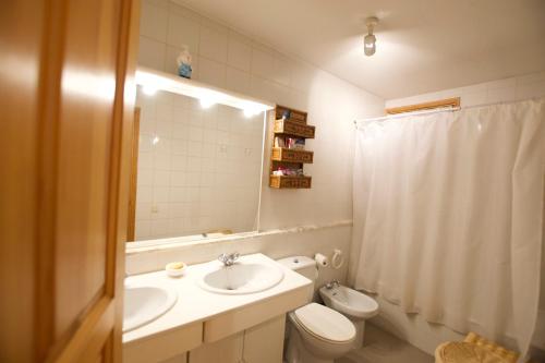 ein Badezimmer mit einem Waschbecken, einem WC und einem Spiegel in der Unterkunft Casa Torreons in Puigcerdà