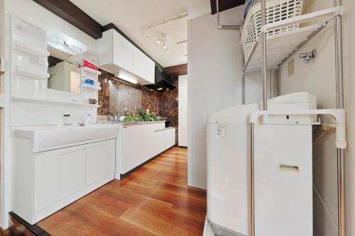 a kitchen with white cabinets and a refrigerator at Terrace Terano#201 in Tokyo