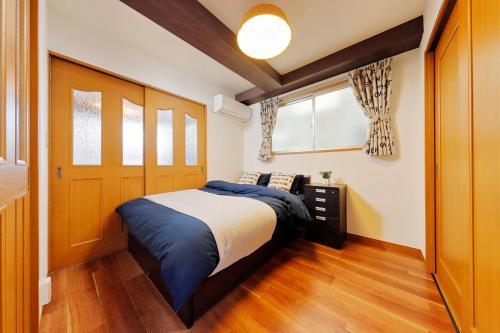 1 dormitorio con 1 cama y puerta de madera en Terrace Terano#201 en Tokio