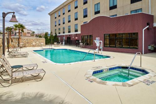 a swimming pool in front of a building at Holiday Inn Express & Suites El Paso Airport by IHG in El Paso