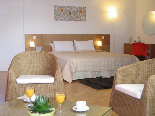 1 dormitorio con 1 cama, 2 sillas y mesa en Allegra GSP Sport Center en Nicosia