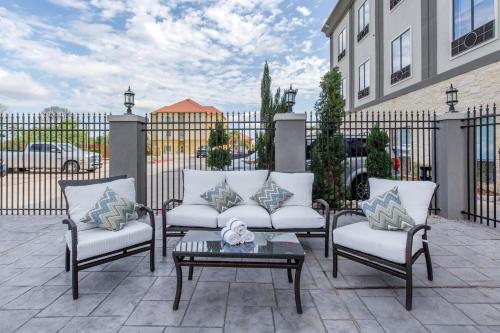 a patio with three chairs and a table and a fence at Holiday Inn Express Houston-Alvin by IHG in Alvin