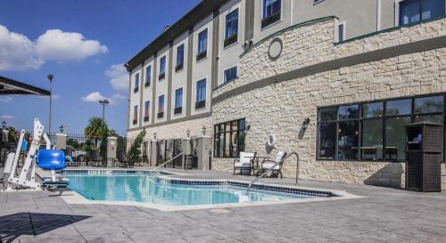 une piscine en face d'un bâtiment dans l'établissement Holiday Inn Express Houston-Alvin, an IHG Hotel, à Alvin