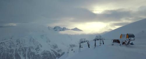 a ski lift on a snow covered mountain with the sky at Nuit a Pleiney in Saint-Rhémy-en-bosses