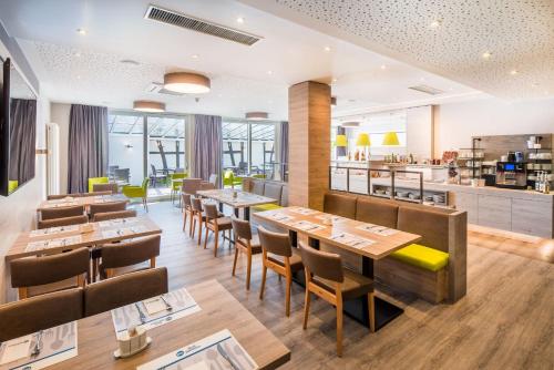 莫尔巴赫Best Western Hotel St. Michael的有木桌椅的餐厅