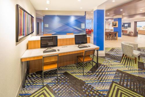 WhitestownにあるHoliday Inn Express & Suites - Indianapolis NW - Zionsville, an IHG Hotelのデスクにコンピュータモニターが2台ある事務所