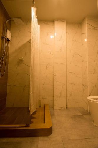 a bathroom with a shower and a toilet and a sink at Thap Sakae Hotel in Thap Sakae