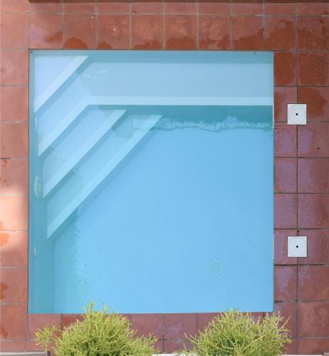 a blue sign on a brick wall with two plants at Ten To Go Hostel in Barcelona