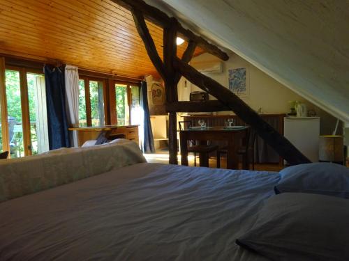 a bedroom with a bed and a kitchen with windows at Les Gites Accromagnon, Climatisation in Les Eyzies-de-Tayac