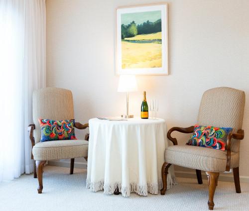 a table with two chairs and a bottle of wine at Bayview Hotel in Bar Harbor