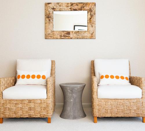 two wicker chairs and a mirror on a wall at Bayview Hotel in Bar Harbor