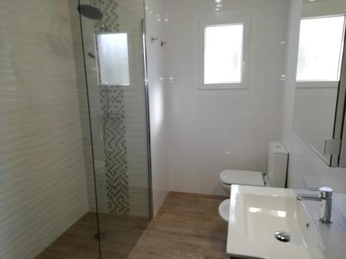 a bathroom with a glass shower and a sink at Pite in Moraira
