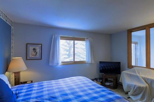 a blue bedroom with a bed and a television at Katsos Ranch Retreat in Vail