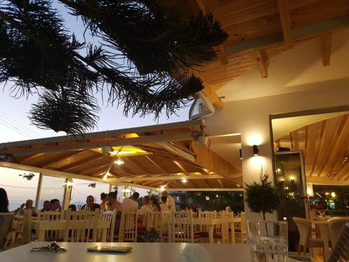 eine Gruppe von Menschen, die an einem Tisch in einem Restaurant sitzen in der Unterkunft Hotel Ardiani in Ksamil
