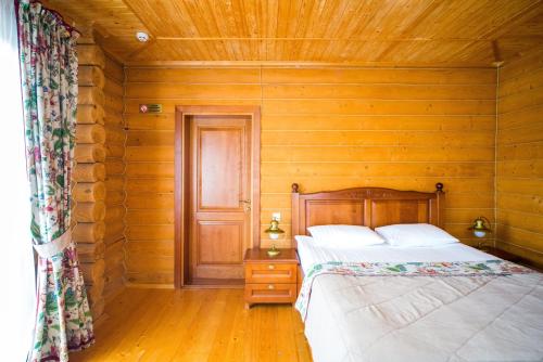 a bedroom with a bed and a wooden wall at Комплекс відпочинку Пампушка & Подушка in Odesa