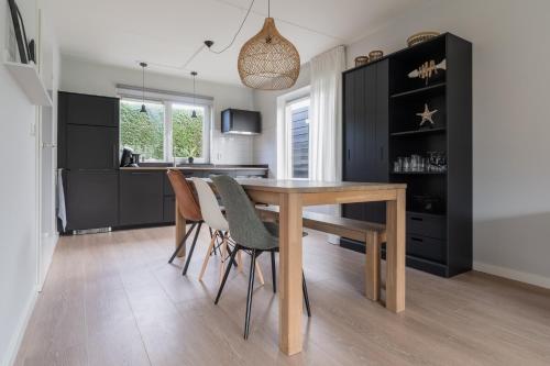 a dining room with a wooden table and chairs at Vakantiewoning Seaside in Oostkapelle