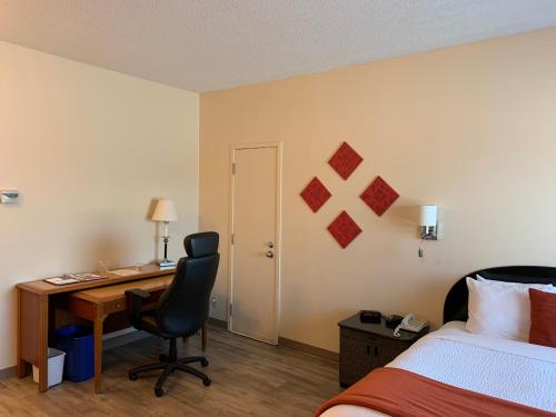 a hotel room with a desk and a bed at Days Inn by Wyndham Berthierville in Berthierville