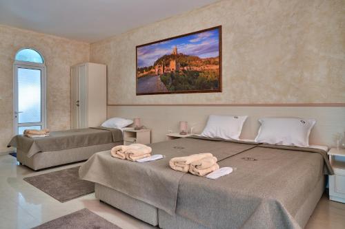 a bedroom with two beds and a painting on the wall at Kings View in Veliko Tŭrnovo