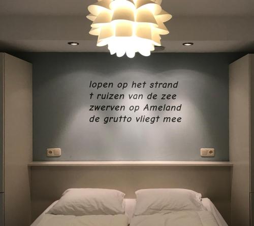 ホルムにあるGrutto in De Kaap 2 pのベッドルーム1室(ベッドの上にシャンデリアが備わる壁付)