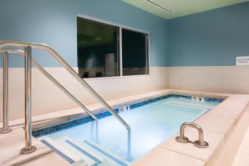 a swimming pool with a hot tub and a window at Holiday Inn Express & Suites - Ely by IHG in Ely