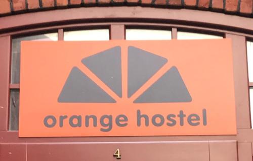una señal de hospital naranja en la ventana de un edificio en Hostel Orange, en Toruń