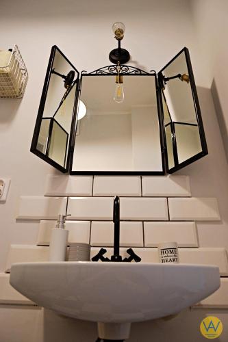 a bathroom sink with a mirror on a wall at Apartamenty Wójcik Loft in Gdynia