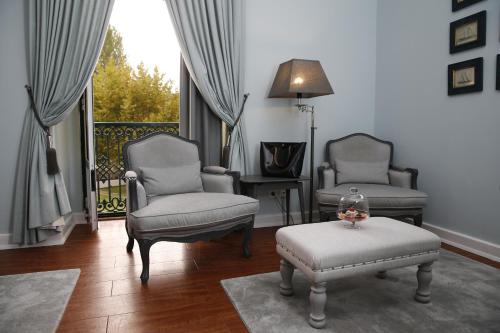 a living room with two chairs and a table at Grande Hotel das Caldas da Felgueira in Caldas da Felgueira