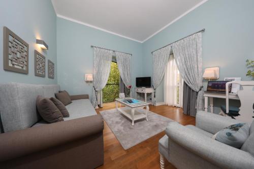 a living room with two couches and a television at Grande Hotel das Caldas da Felgueira in Caldas da Felgueira