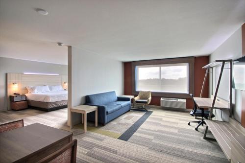 a hotel room with a bed and a blue couch at Holiday Inn Express & Suites Fond Du Lac by IHG in Fond du Lac