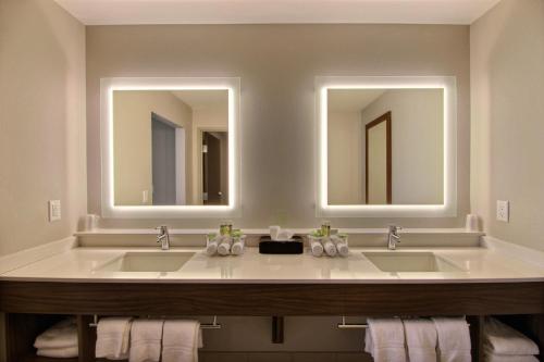 a bathroom with two sinks and a mirror at Holiday Inn Express & Suites Fond Du Lac, an IHG Hotel in Fond du Lac