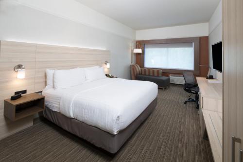 a hotel room with a large bed and a television at Holiday Inn Express & Suites La Porte by IHG in LaPorte