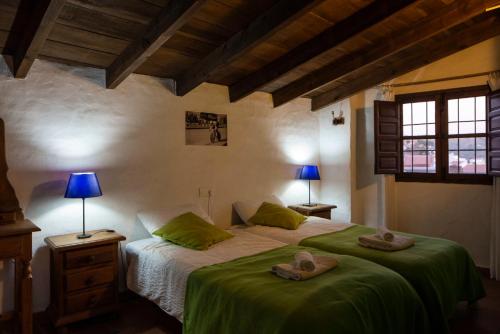 a bedroom with a bed with two hats on it at Casa de Luz in Almáchar