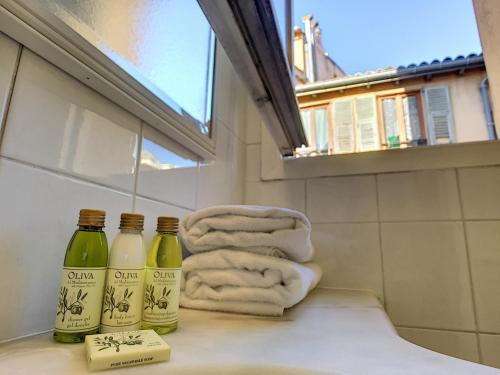 - une salle de bains avec 2 bouteilles de savon et des serviettes dans l'établissement Nestor&Jeeves - FRANCOIS VIEUX NICE - Old Town - Close sea, à Nice