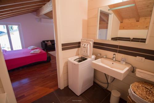 a bathroom with a sink and a mirror and a bed at Appartamento La Vigna in Sala Comacina