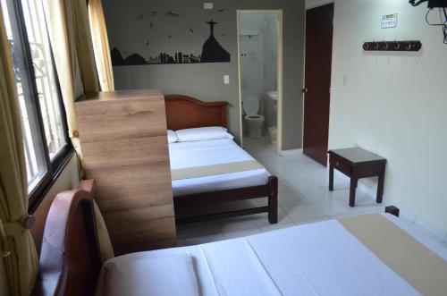 a small bedroom with a bed and a bathroom at Hotel Balcon Llanero in Cúcuta
