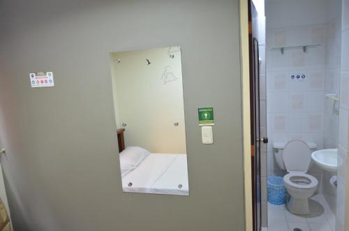 a small bathroom with a toilet and a mirror at Hotel Balcon Llanero in Cúcuta