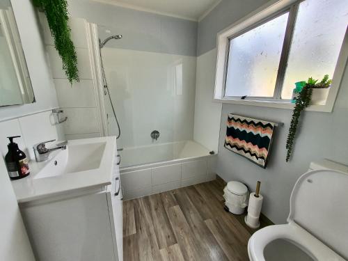 La salle de bains est pourvue d'un lavabo, de toilettes et d'une fenêtre. dans l'établissement Little Glennie - Blenheim Holiday Home, à Blenheim