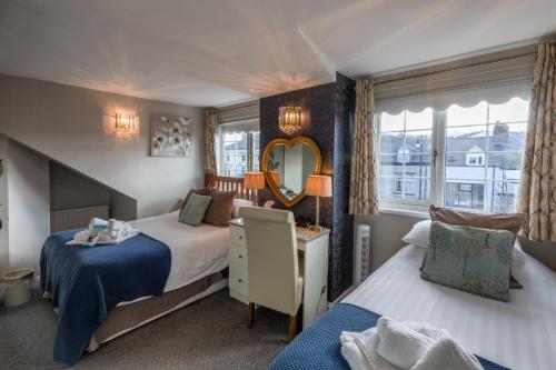 a bedroom with two beds and a mirror at Forest Guest House in South Shields