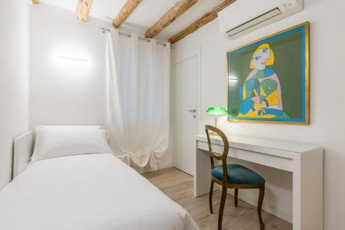 een slaapkamer met een bed, een bureau en een stoel bij Hermes San Marco in Venetië