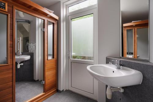 een badkamer met 2 wastafels en een raam bij vakantiehuis Seaside, Dunoweg 18 in Oostkapelle