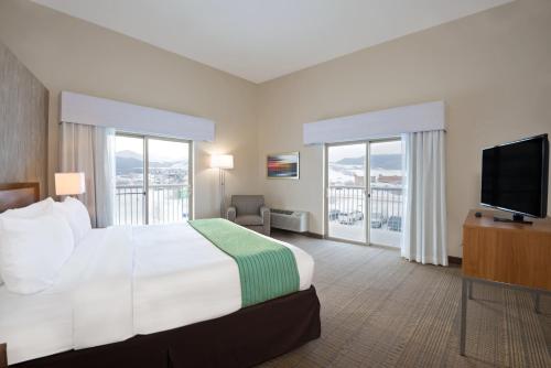 a hotel room with a bed and a flat screen tv at Holiday Inn Express Hotel & Suites Fraser Winter Park Area by IHG in Fraser