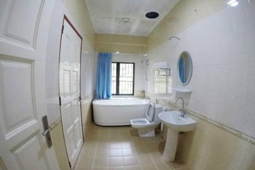 a bathroom with a sink and a toilet and a bath tub at Bonsai Villa @ Mesilou 盆栽小苑 in Kundasang